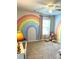 Rainbow themed bedroom with a plush teddy bear and natural light from the window at 110 Serendipity Way, Dallas, GA 30157