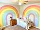 Bright bedroom featuring a colorful rainbow wall mural, ceiling fan, and cozy bed at 110 Serendipity Way, Dallas, GA 30157
