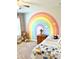 Bright bedroom decorated with rainbow art, a teddy bear and natural light from the window at 110 Serendipity Way, Dallas, GA 30157