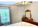 Bright bedroom featuring a wooden dresser and a large window with leafy green views at 110 Serendipity Way, Dallas, GA 30157