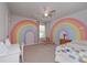 Bright bedroom featuring creative rainbow wall art and a cozy quilt-covered bed at 110 Serendipity Way, Dallas, GA 30157