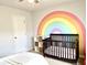 Bright Bedroom with rainbow wall art, a dark wood crib, and natural light from the large window at 110 Serendipity Way, Dallas, GA 30157