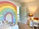 Bright room with a fun rainbow wall mural, open door, and desk at 110 Serendipity Way, Dallas, GA 30157