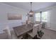 Traditional dining room featuring a gray wood table, seating for six, and natural light from a bright window at 110 Serendipity Way, Dallas, GA 30157