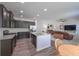 Open kitchen featuring an island, stainless steel appliances, granite countertops and dark cabinets with open view to the living room at 110 Serendipity Way, Dallas, GA 30157