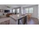 Open kitchen featuring a granite island, stainless steel appliances and dark wood cabinets with view to the living room at 110 Serendipity Way, Dallas, GA 30157