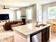 Open kitchen with granite island overlooking living room and adjacent dining area at 110 Serendipity Way, Dallas, GA 30157