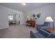 Cozy living room with neutral walls, carpeted floors, and an arched entryway to the formal dining room at 110 Serendipity Way, Dallas, GA 30157