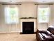 Cozy living room featuring a fireplace with white mantle and windows with white drapes at 110 Serendipity Way, Dallas, GA 30157