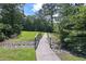 Scenic community walking bridge over a rocky creek, connecting green spaces and nature trails at 110 Serendipity Way, Dallas, GA 30157