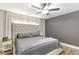 Bedroom with a tufted headboard, neutral color palette, a ceiling fan, and dark gray accent wall at 4002 Joshua Ln, Douglasville, GA 30135