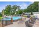 Backyard pool with deck seating, a home and a garage surrounded by mature trees at 4002 Joshua Ln, Douglasville, GA 30135
