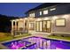 Backyard featuring a stunning pool illuminated with vibrant purple lights and an outdoor living space at 1312 Becket Ne Dr, Brookhaven, GA 30319
