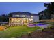 Backyard at dusk featuring a pool, patio area, and well-maintained landscaping, perfect for entertaining at 1312 Becket Ne Dr, Brookhaven, GA 30319