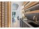 Modern bar area featuring a wine rack, sink, and view to the dining room and backyard at 1312 Becket Ne Dr, Brookhaven, GA 30319