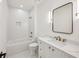 White bathroom features a shower, bathtub, toilet, single vanity with marble countertop, and mirror at 1312 Becket Ne Dr, Brookhaven, GA 30319