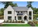 Charming two-story home features a white brick facade, black framed windows, manicured lawn and well-designed landscaping at 1312 Becket Ne Dr, Brookhaven, GA 30319
