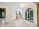 Foyer with stairs, grand chandelier, and large arched doors and windows letting in ample light at 1312 Becket Ne Dr, Brookhaven, GA 30319