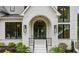 A close-up of the front entrance shows an arched doorway, manicured plants, and black-framed windows at 1312 Becket Ne Dr, Brookhaven, GA 30319