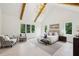 Bright primary bedroom suite with hardwood floors, vaulted ceilings, and a seating area by the windows at 1312 Becket Ne Dr, Brookhaven, GA 30319