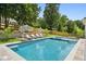 An inviting backyard pool with a hot tub, lounge chairs, and umbrella on the well maintained lawn at 1312 Becket Ne Dr, Brookhaven, GA 30319