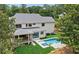Rear exterior view with large pool and patio area, with green lawn, set against a lush treed backdrop at 1312 Becket Ne Dr, Brookhaven, GA 30319