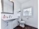 This half bathroom has a pedestal sink, toilet and window at 2140 Colvin Nw Ct, Atlanta, GA 30318