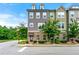 A well-maintained three-story townhome showcasing a mix of brick and siding accents on a landscaped corner lot at 2140 Colvin Nw Ct, Atlanta, GA 30318