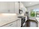 Modern kitchen with stainless steel appliances, white cabinets, granite countertops, and tile backsplash at 2140 Colvin Nw Ct, Atlanta, GA 30318
