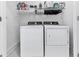 Modern laundry room with white washer and dryer units, overhead shelving at 2140 Colvin Nw Ct, Atlanta, GA 30318