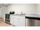 Kitchenette featuring stainless dishwasher, white cabinets, stainless appliances, and granite counters at 505 Samaritan Dr, Cumming, GA 30040