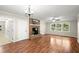 Bright living room features hardwood floors, a cozy brick fireplace, and large windows offering serene outdoor views at 505 Samaritan Dr, Cumming, GA 30040