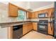 Bright kitchen features granite counters, wooden cabinets, and black appliances at 5137 Allison Way, Sugar Hill, GA 30518