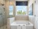 Bright bathroom with a soaking tub and separate glass-enclosed shower offering views of the landscape and a tranquil escape at 5415 Trescott Path, Cumming, GA 30028