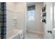 Bright bathroom with a shower/tub combo, window, and organized storage at 5415 Trescott Path, Cumming, GA 30028