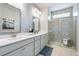 Elegant bathroom with dual sinks, quartz countertops and glass-enclosed shower at 5415 Trescott Path, Cumming, GA 30028
