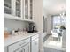 Well-appointed kitchen features white cabinets, herringbone backsplash, and a beverage station near the dining area at 5415 Trescott Path, Cumming, GA 30028