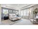 A beautifully staged main bedroom with ample natural light, neutral tones, and a seating area by the large windows at 5415 Trescott Path, Cumming, GA 30028