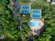 Aerial view of community tennis courts and swimming pool, surrounded by lush trees at 1350 Rivershyre Pkwy, Lawrenceville, GA 30043