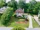 Aerial view of two-story brick home and its long drive, nestled among lush trees at 1350 Rivershyre Pkwy, Lawrenceville, GA 30043