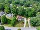 Aerial view of a suburban neighborhood with lush trees, showcasing this two-story brick home at 1350 Rivershyre Pkwy, Lawrenceville, GA 30043