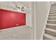 Finished basement area with a red accent wall and carpeted flooring next to carpeted staircase at 1350 Rivershyre Pkwy, Lawrenceville, GA 30043