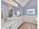 Bathroom features a white double vanity, a soaking tub, tile floors, and decorative windows at 1350 Rivershyre Pkwy, Lawrenceville, GA 30043