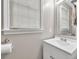 Bright bathroom featuring a white single sink vanity and large mirror with natural light at 1350 Rivershyre Pkwy, Lawrenceville, GA 30043