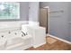 Bright bathroom featuring a large tub, a tiled seat, and a shower in a neutral color palette at 1350 Rivershyre Pkwy, Lawrenceville, GA 30043
