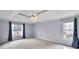 Spacious bedroom with tray ceiling, ceiling fan, and windows dressed with blue curtains at 1350 Rivershyre Pkwy, Lawrenceville, GA 30043