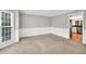 Carpeted dining room with chair rail, large window, and view into adjacent kitchen at 1350 Rivershyre Pkwy, Lawrenceville, GA 30043