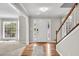 Bright foyer with hardwood floors, staircase, and a view into the front windowed living room at 1350 Rivershyre Pkwy, Lawrenceville, GA 30043
