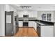 Well-lit kitchen with stainless steel appliances, granite counters, and white cabinets at 1350 Rivershyre Pkwy, Lawrenceville, GA 30043