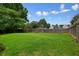 Expansive backyard with lush lawn, bordered by mature trees and a wooden privacy fence at 3635 Bardfield Ct, Cumming, GA 30041